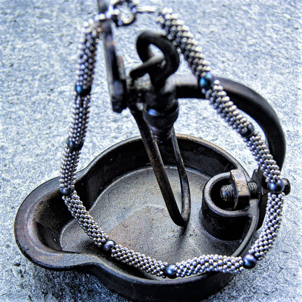 Kjede med grå ferskvannsperler og metallringer